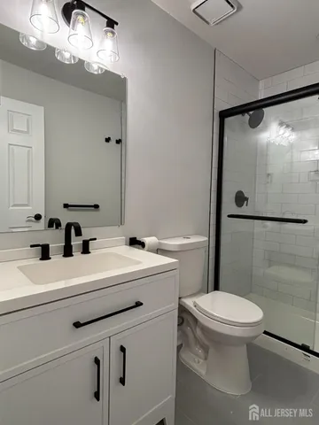 a bathroom with a sink a mirror a toilet and shower