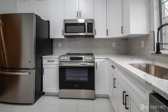 a kitchen with stainless steel appliances granite countertop a refrigerator stove and sink