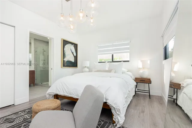 a spacious bedroom with a bed and a chandelier