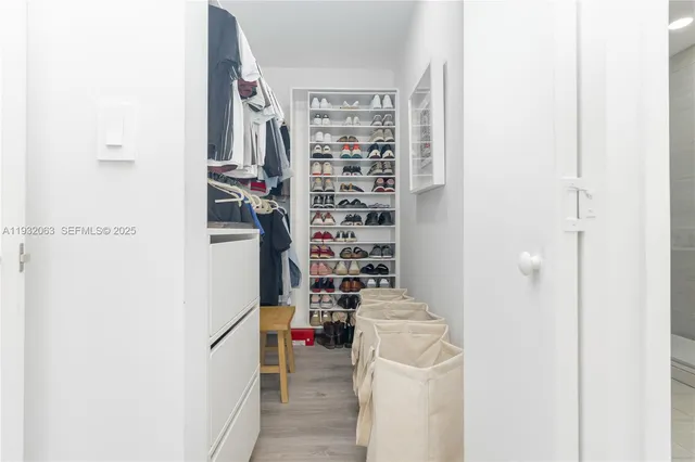 a view of walk in closet with clothes and shoes