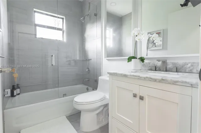 a bathroom with a granite countertop toilet a sink and bathtub