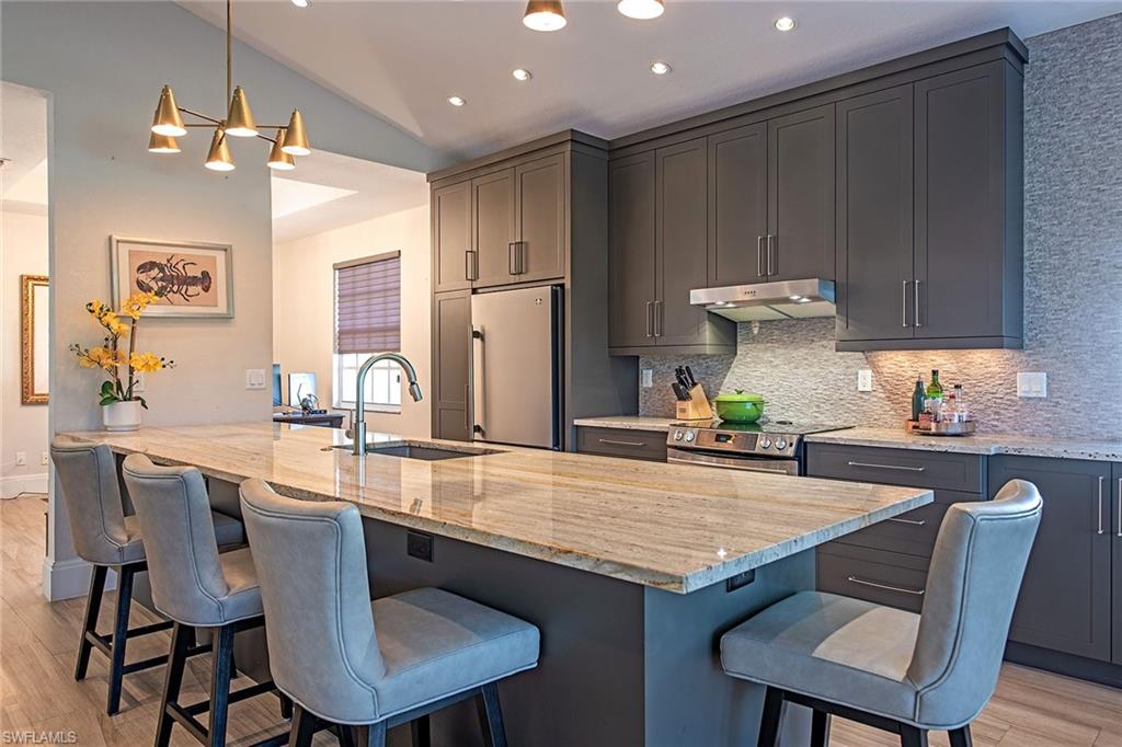 7115 Wild Forest Court, Unit 201 Naples, FL 34109 - Photo 6 of 18 a dining table with chairs and wooden floor