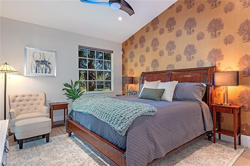 7115 Wild Forest Court, Unit 201 Naples, FL 34109 - Photo 7 of 18 a bedroom with a large bed and a couch