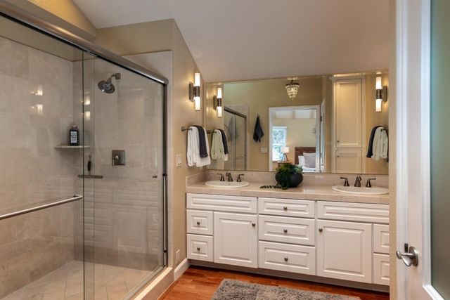 a bathroom with a double vanity sink mirror and shower