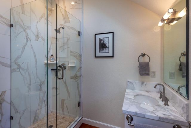 a bathroom with a sink vanity and shower