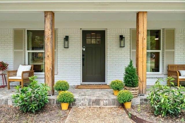 a hallway with a view of bedroom with wooden floor