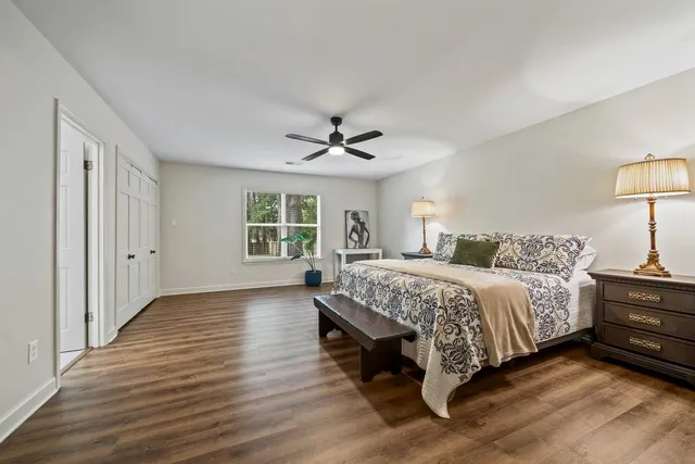 a spacious bedroom with a bed and a lamp