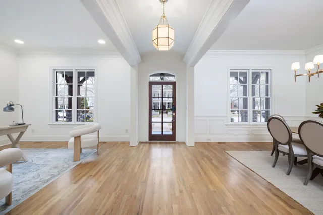 a living room with furniture wooden floor and a kitchen view