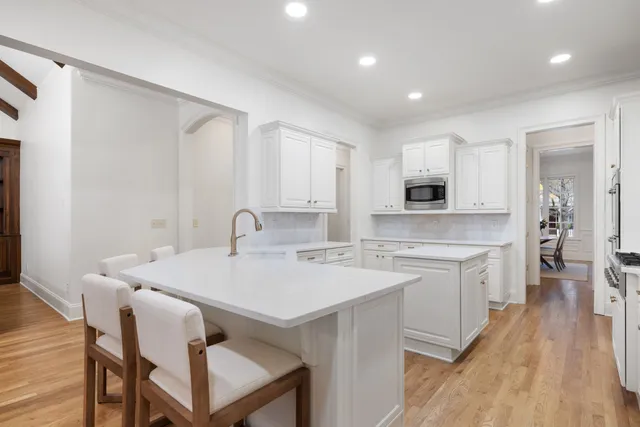 a bathroom with a toilet sink vanity granite and shower
