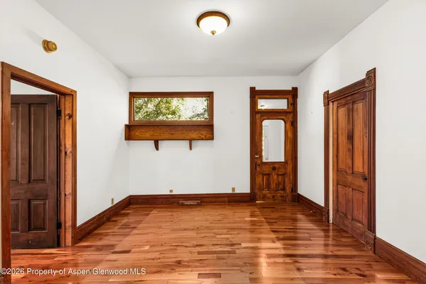 a view of empty room with wooden floor and window