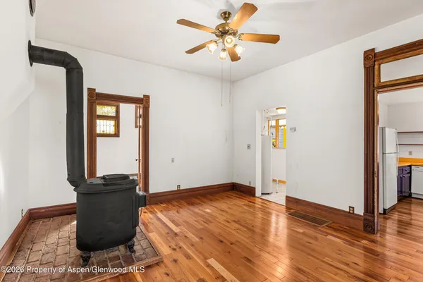 a view of a livingroom with wooden floor and a ceiling fan