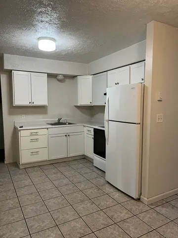 a kitchen with cabinets stainless steel appliances and a counter space