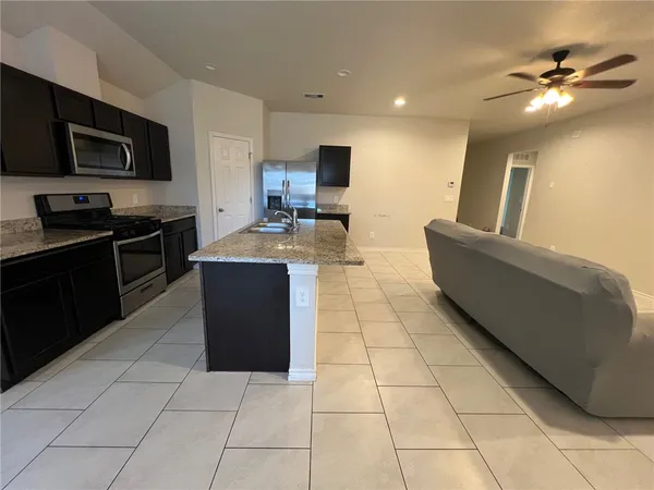 a kitchen with a sink a counter top space appliances and cabinets