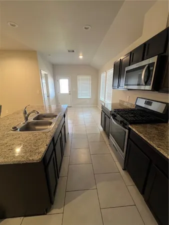 a kitchen with stainless steel appliances granite countertop a sink and a stove