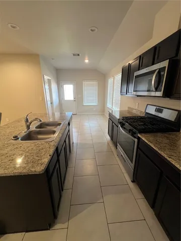 a kitchen with stainless steel appliances granite countertop a sink and a stove