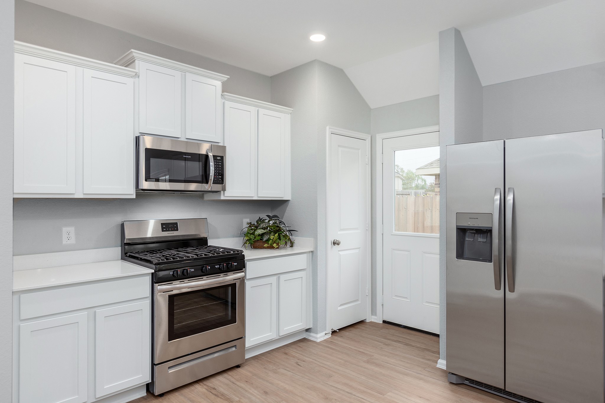 6327 Arcadia Sound Lane Houston, TX 77365 - Photo 12 of 33 a kitchen with stainless steel appliances white cabinets white stove a microwave and a refrigerator