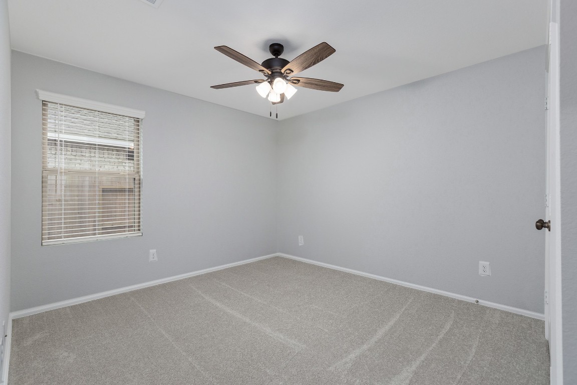 6327 Arcadia Sound Lane Houston, TX 77365 - Photo 21 of 33 an empty room with a window and a ceiling fan