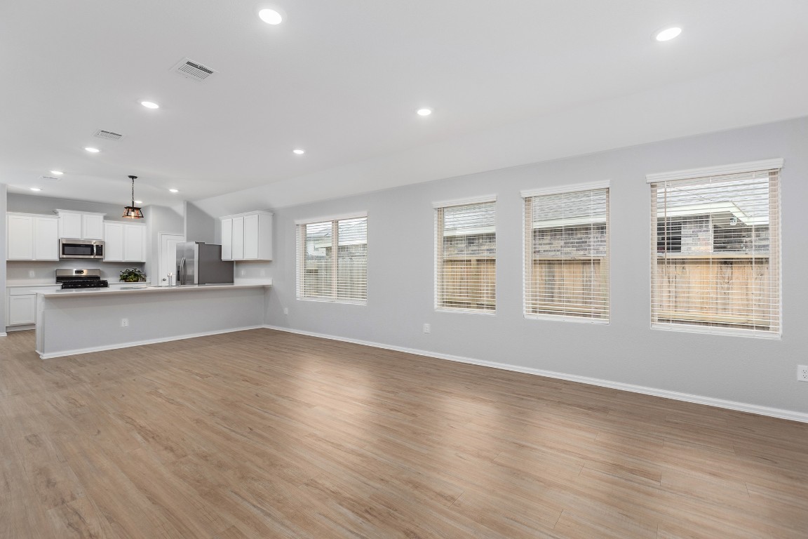 6327 Arcadia Sound Lane Houston, TX 77365 - Photo 7 of 33 a view of an empty room with a window and wooden floor