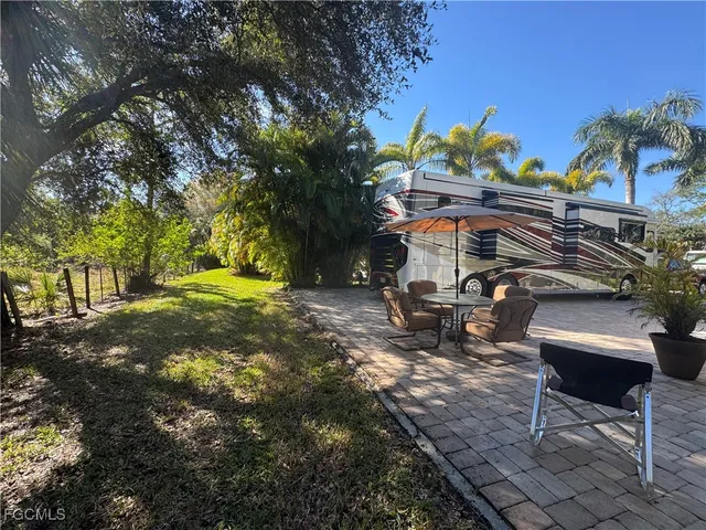 a view of a backyard with table and chairs under an umbrella