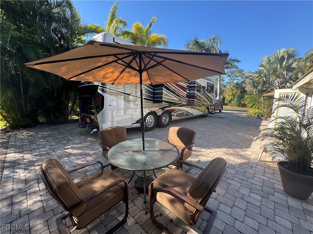 Lot 212-3027 Belle Of Myers Road LaBelle, FL 33935 - Photo 23 of 43 a view of a backyard with table and chairs under an umbrella