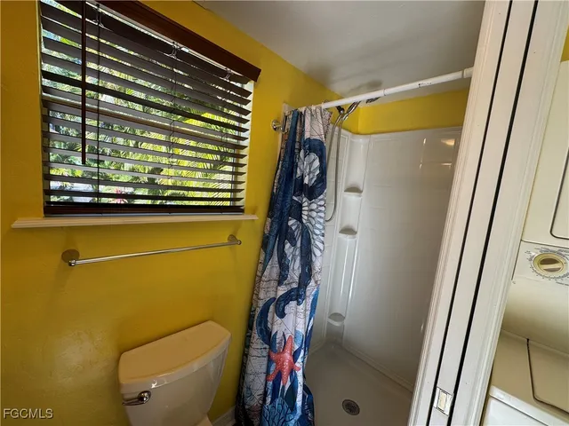 a bathroom with a granite countertop toilet sink and mirror