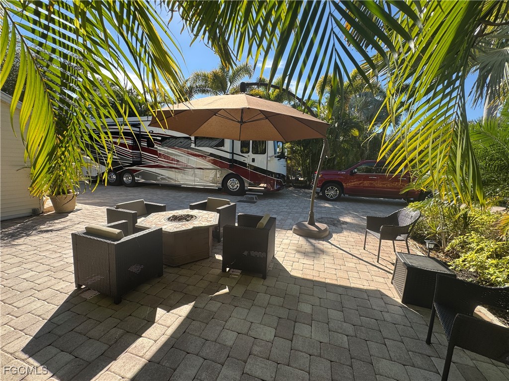 Lot 212-3027 Belle Of Myers Road LaBelle, FL 33935 - Photo 41 of 43 a view of a patio with table and chairs under an umbrella with a barbeque