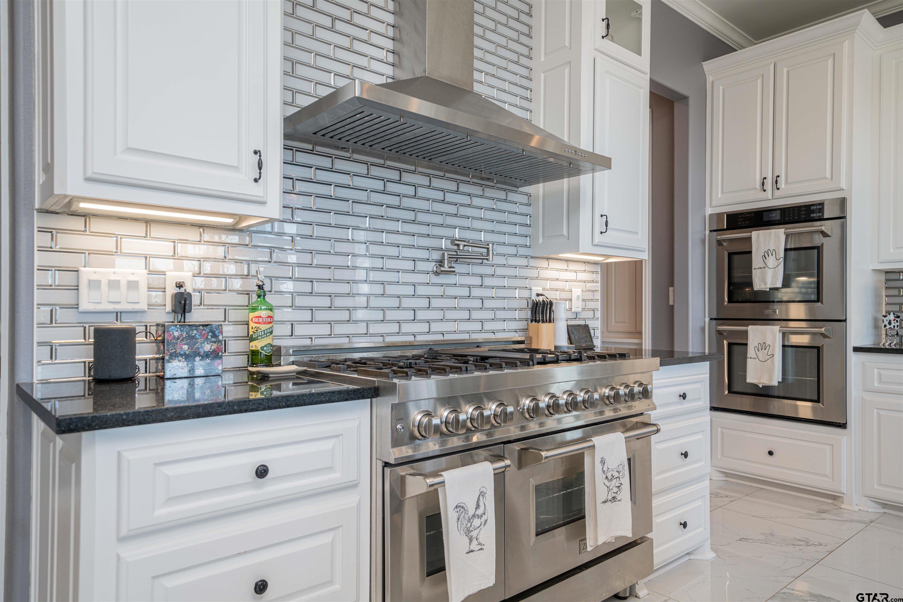 145 Private Road Pittsburg, TX 75686 - Photo 8 of 46 a kitchen with stainless steel appliances granite countertop white cabinets and a stove