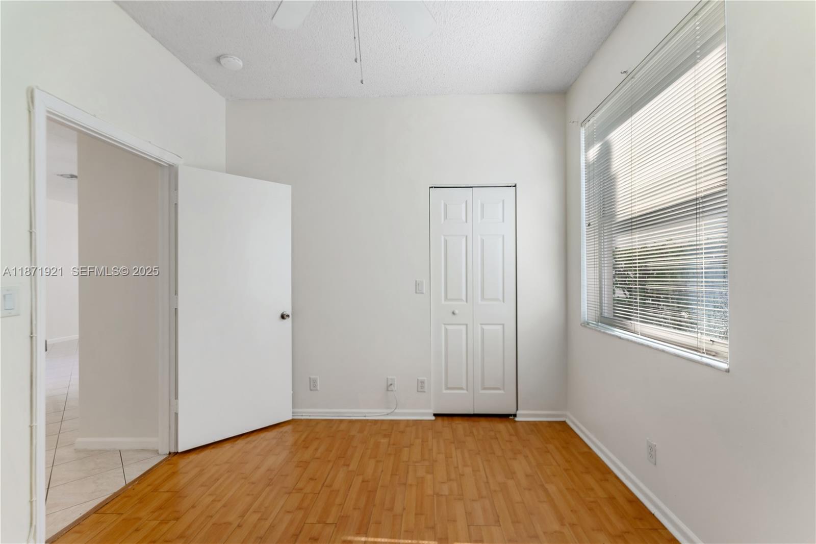 1943 Southwest 149th Avenue Miramar, FL 33027 - Photo 12 of 26 a view of an empty room with wooden floor and a window