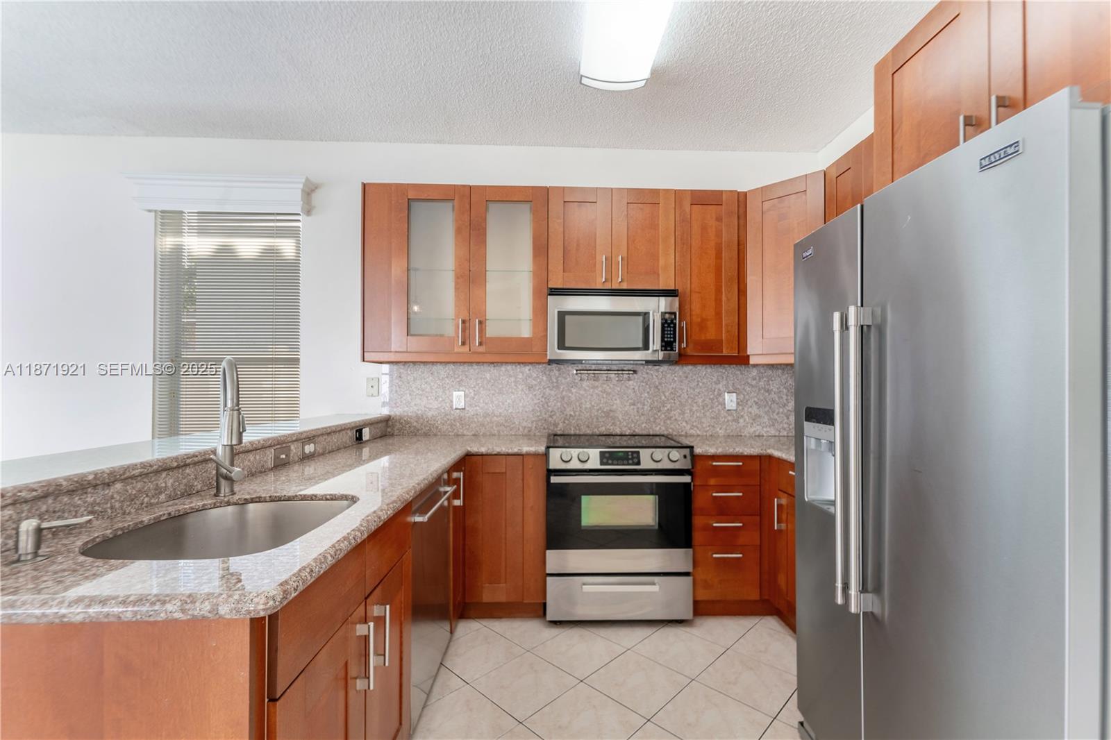 1943 Southwest 149th Avenue Miramar, FL 33027 - Photo 3 of 26 a kitchen with stainless steel appliances granite countertop a sink stove and refrigerator