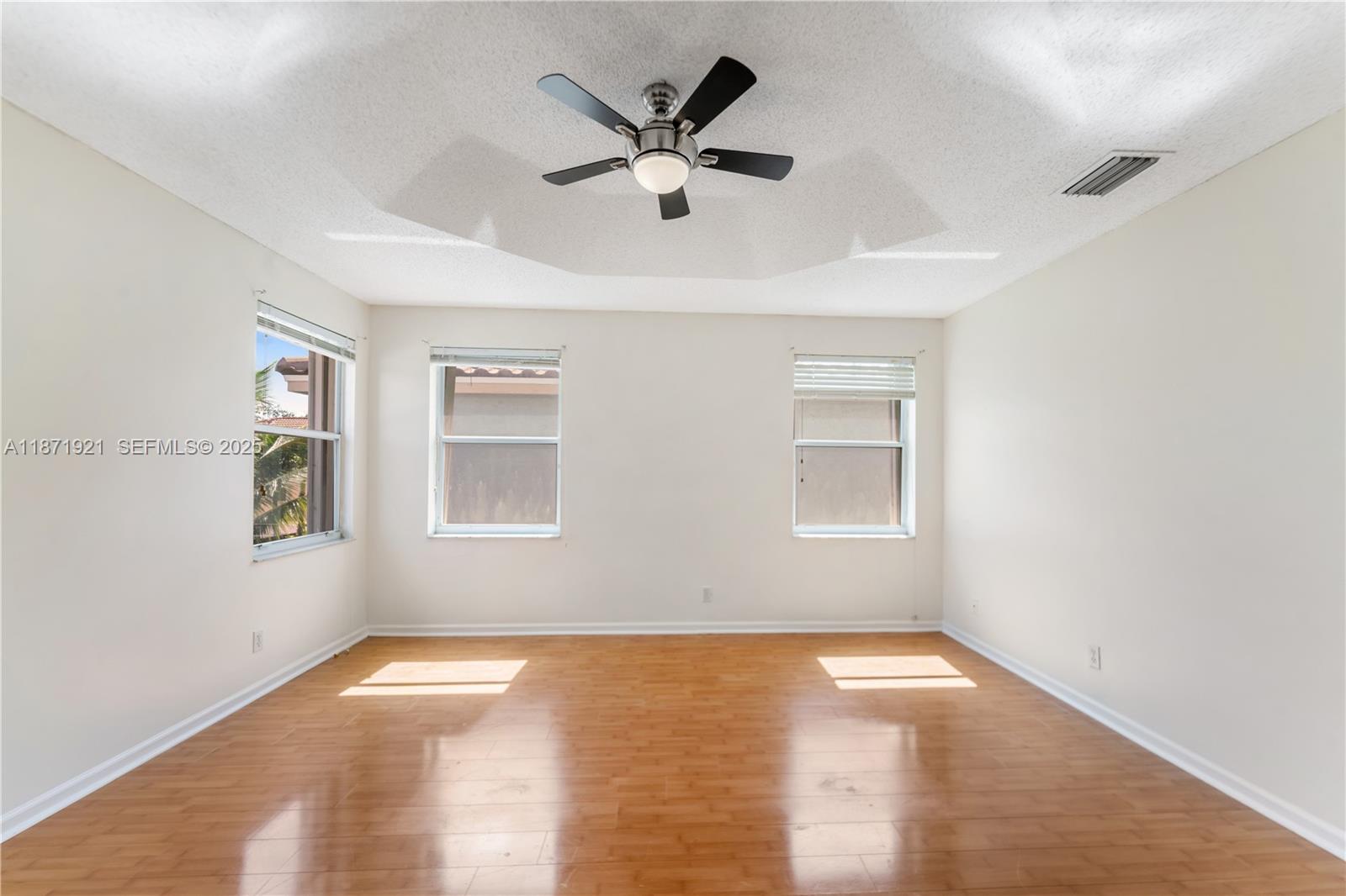 1943 Southwest 149th Avenue Miramar, FL 33027 - Photo 6 of 26 a view of empty room with wooden floor and fan