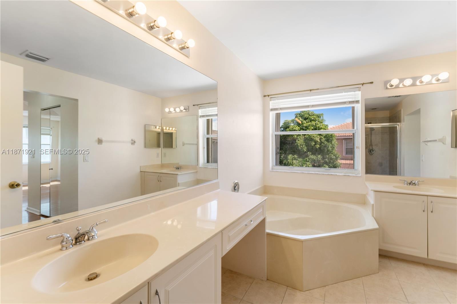 1943 Southwest 149th Avenue Miramar, FL 33027 - Photo 8 of 26 a bathroom with a tub a sink and a large mirror