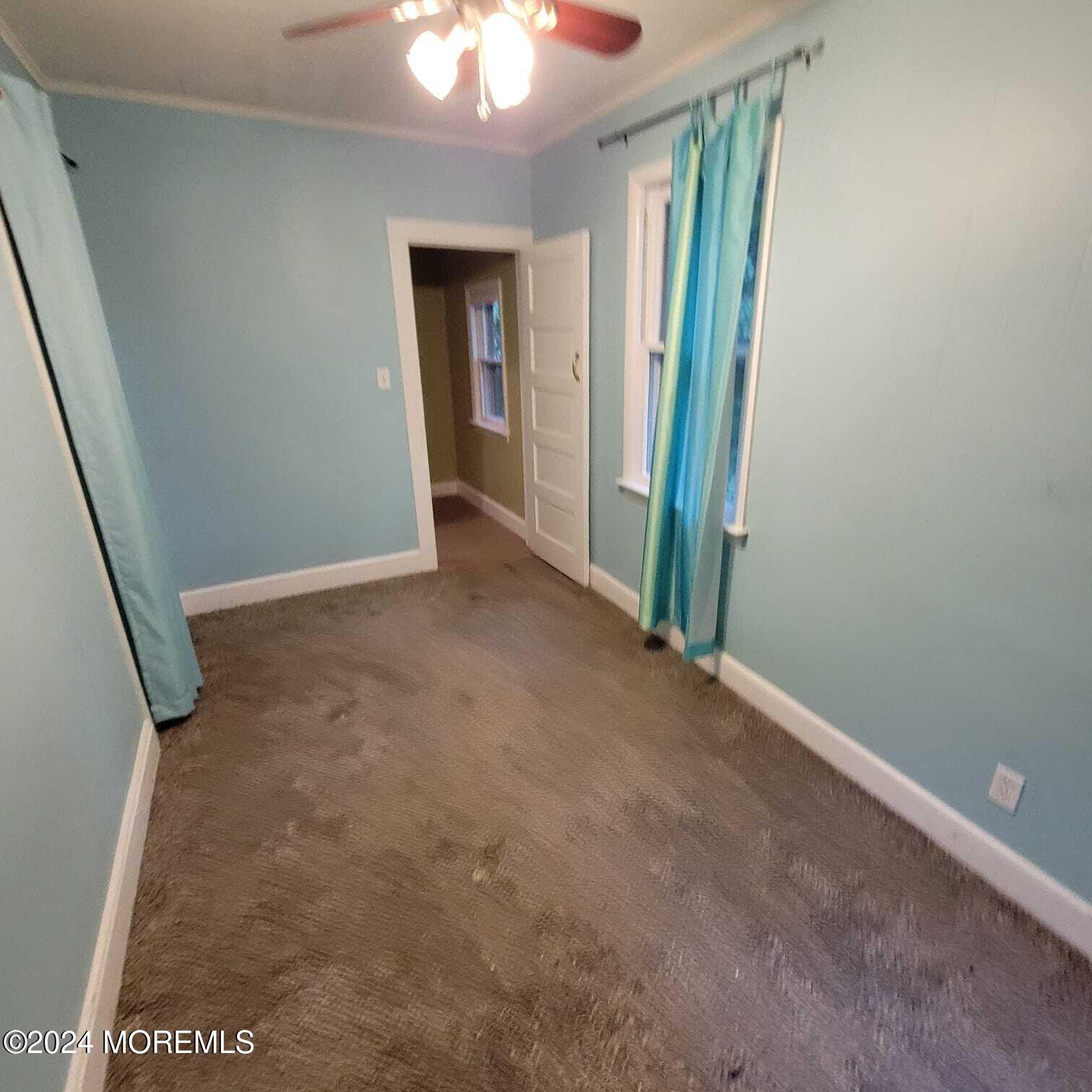 63 Reids Hill Road Morganville, NJ 07751 - Photo 18 of 32 an empty room with closet and a chandelier fan