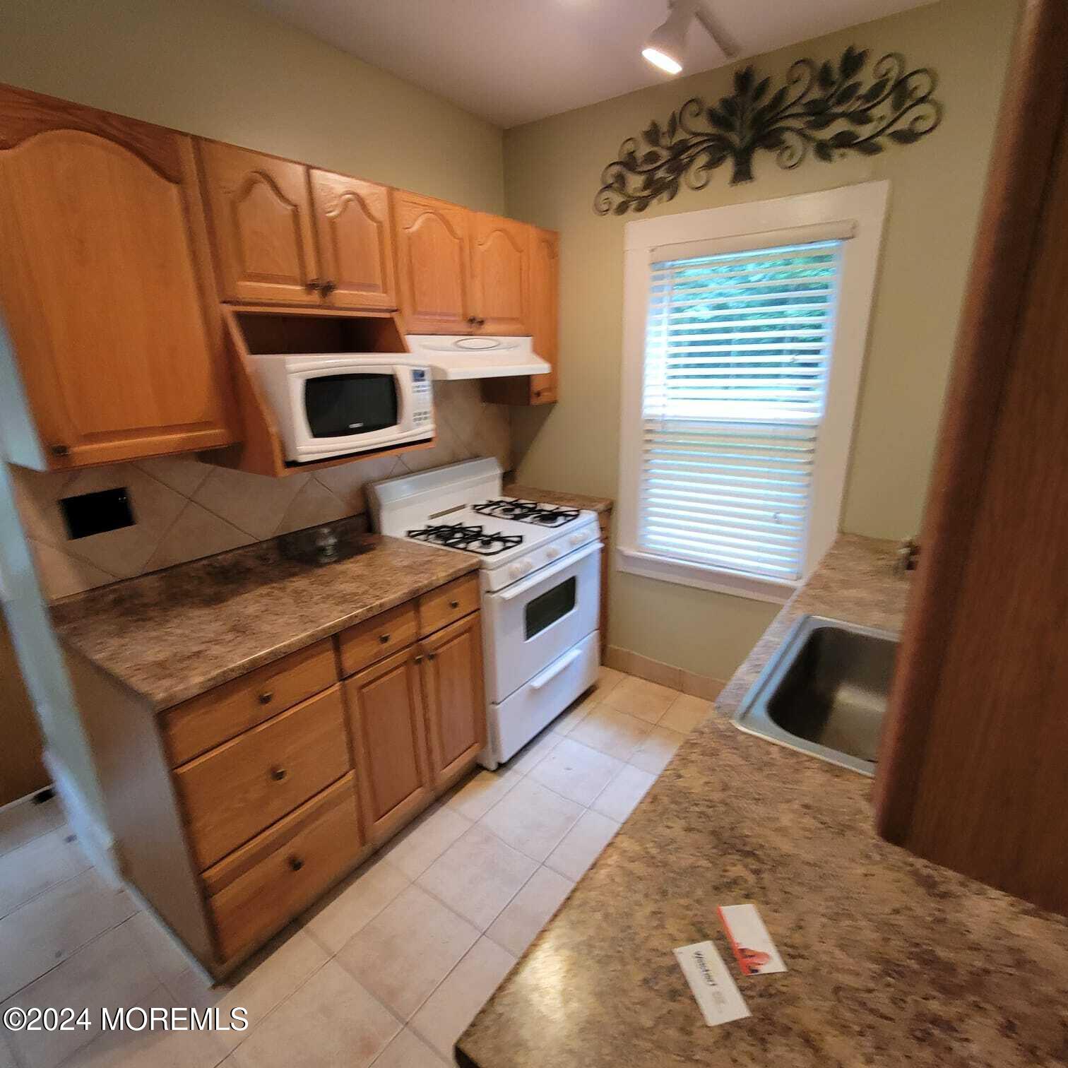 63 Reids Hill Road Morganville, NJ 07751 - Photo 4 of 32 a kitchen with granite countertop a stove a sink and a microwave