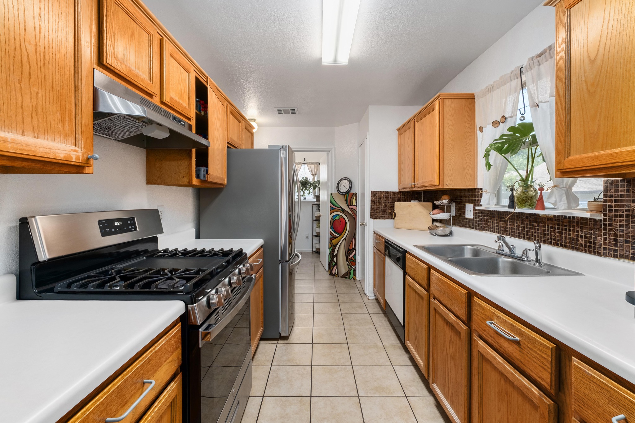 1184 Waller Street Austin, TX 78702 - Photo 5 of 19 a kitchen with stainless steel appliances a sink stove and cabinets