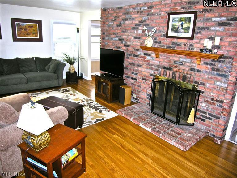 3509 Boynton Road Cleveland Heights, OH 44121 - Photo 3 of 21 Exposed brick wall and wood-burning fireplace add warmth to the living room.