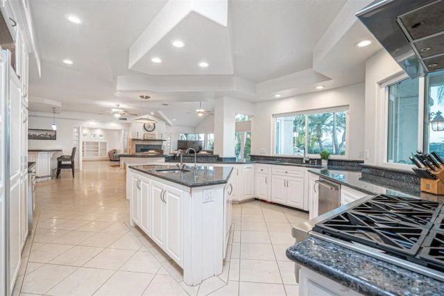 a large white kitchen with lots of counter space a sink and appliances