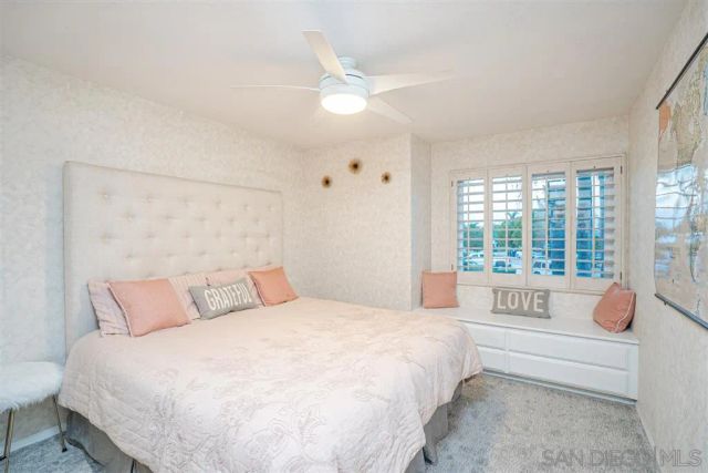 a spacious bedroom with a large bed and a large window with balcony view