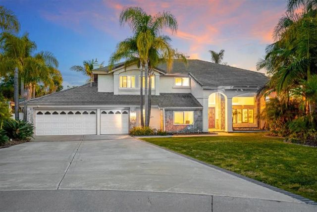 a view of a house with a yard and palm trees