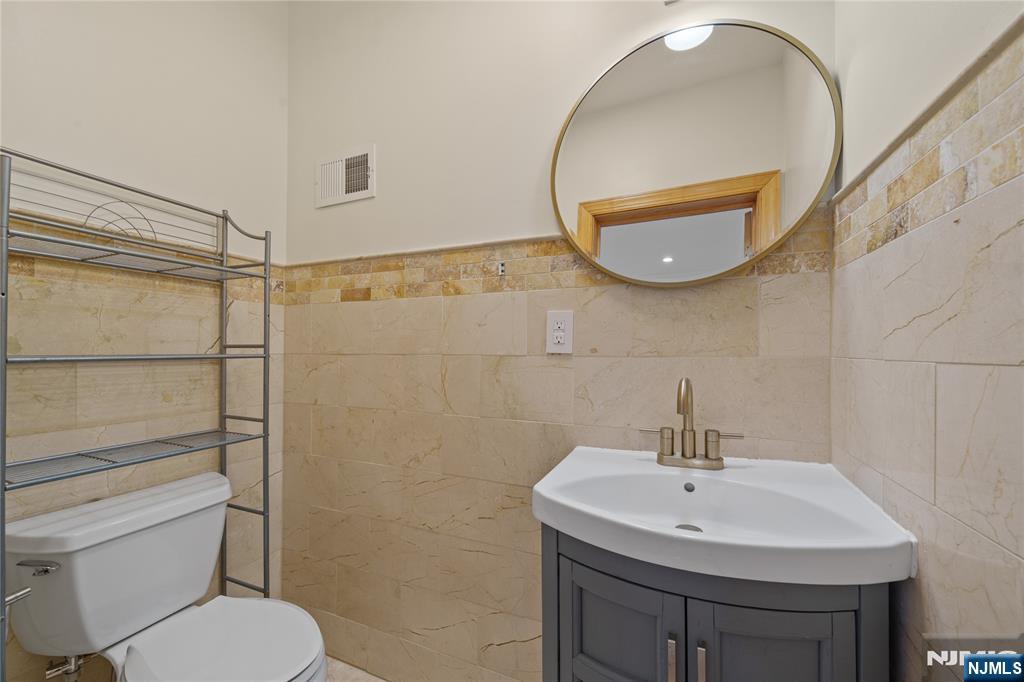 81 Fairmount Avenue Hackensack, NJ 07601 - Photo 12 of 19 a bathroom with a toilet a sink and mirror