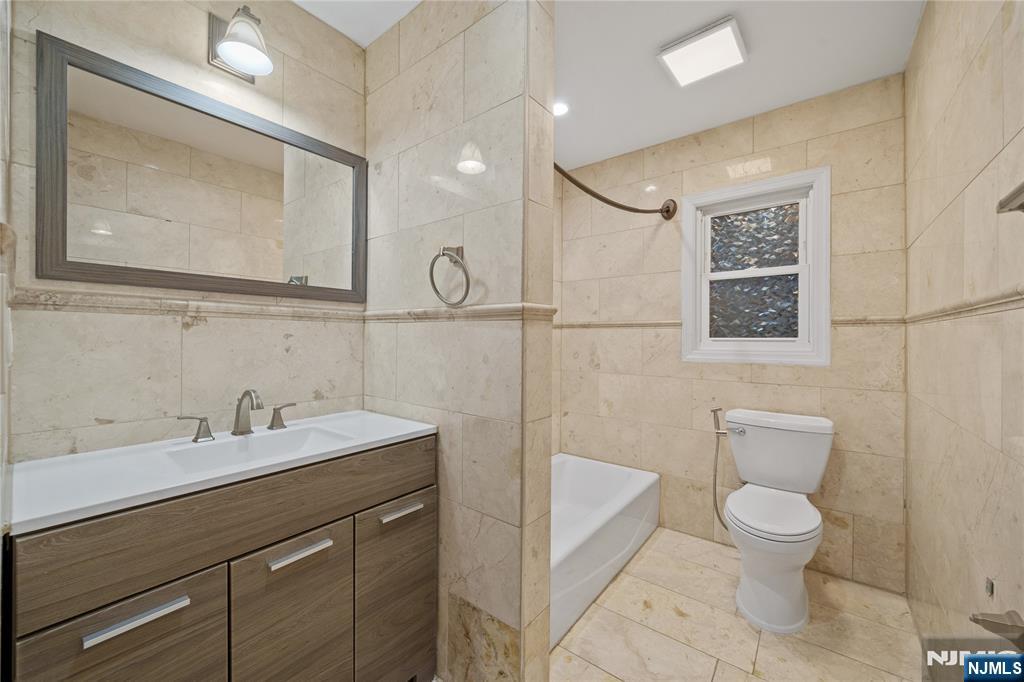 81 Fairmount Avenue Hackensack, NJ 07601 - Photo 15 of 19 a bathroom with a toilet a sink a mirror and a shower