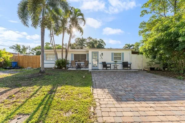 a view of a house with backyard and sitting area