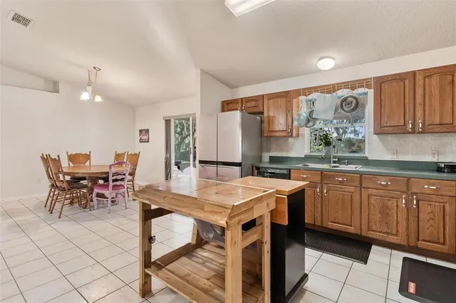 a kitchen with a stove a sink a dining table and chairs