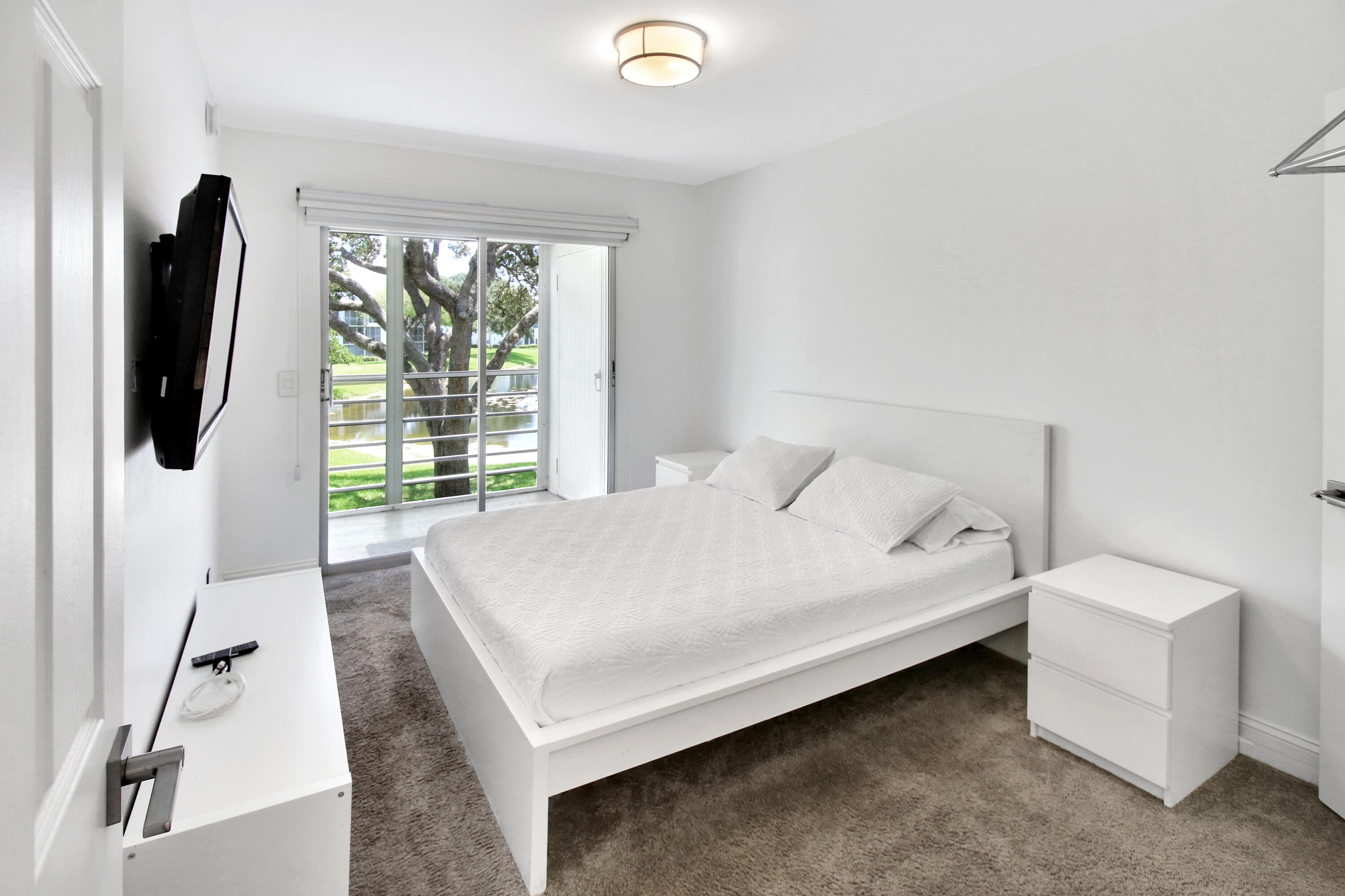 17 Fanshaw A Boca Raton, FL 33434 - Photo 6 of 11 a bedroom with a bed and a flat tv screen on a dresser