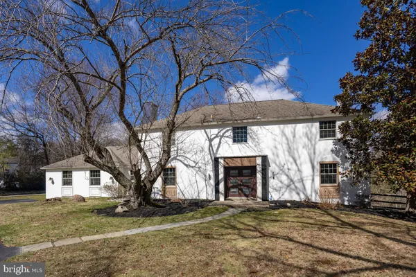 a front view of a house with a yard covered with trees
