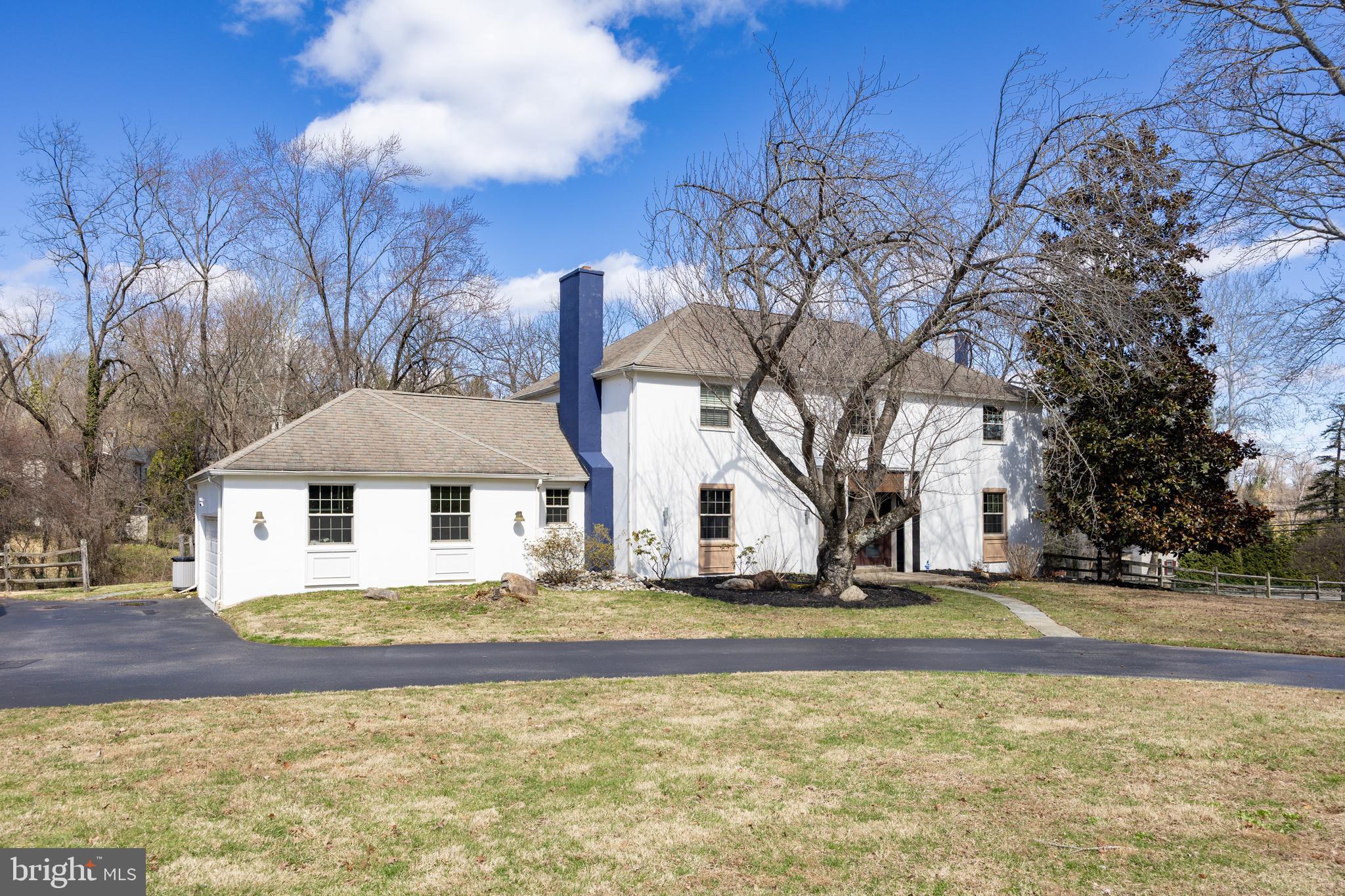 a front view of a house with a yard covered with trees