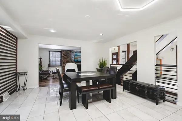 a living room with stainless steel appliances furniture a rug and a kitchen view
