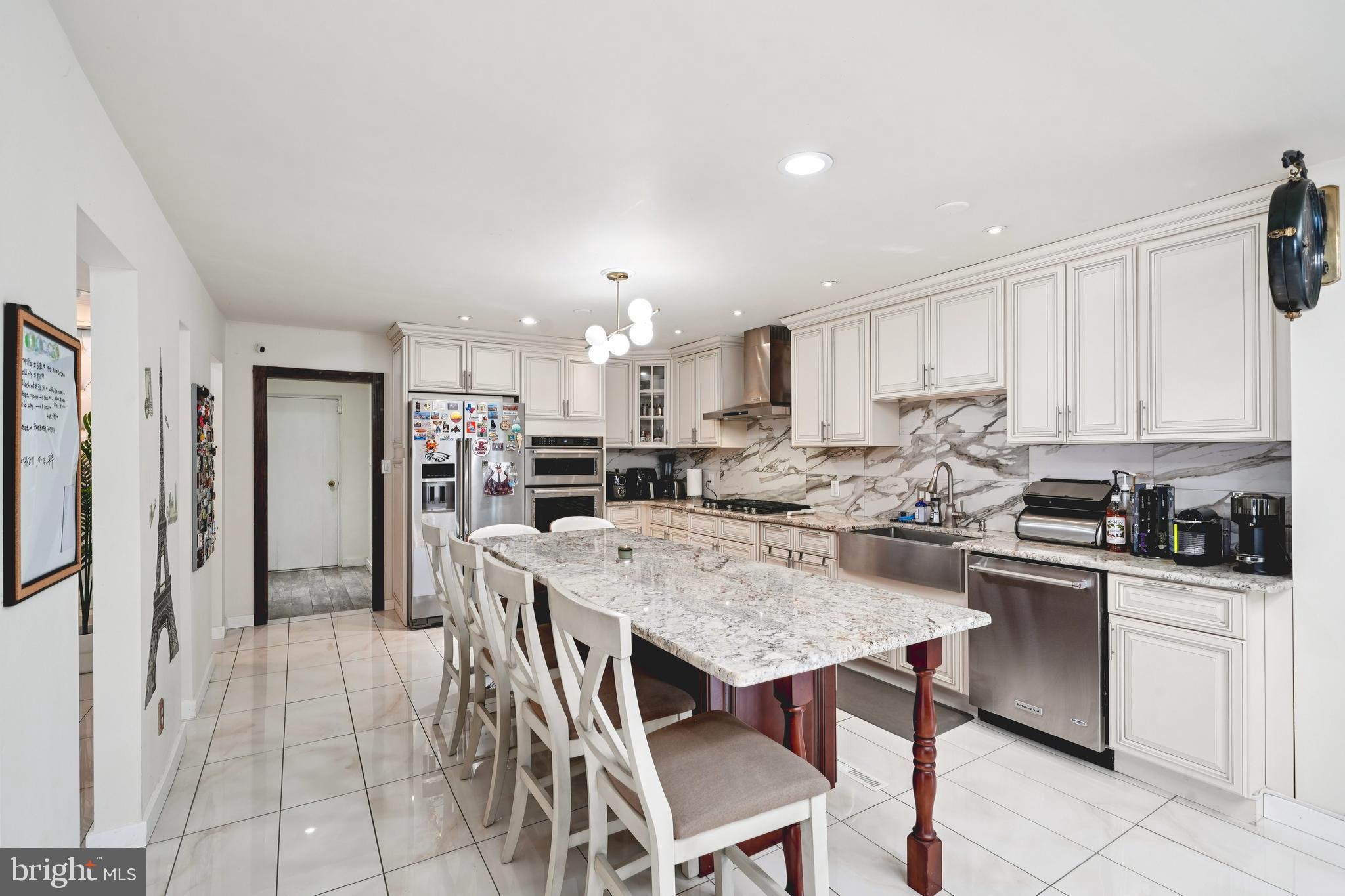 700 Campwoods Road Villanova, PA 19085 - Photo 10 of 72 a kitchen with stainless steel appliances granite countertop a stove top oven a refrigerator a sink and a island with wooden floor