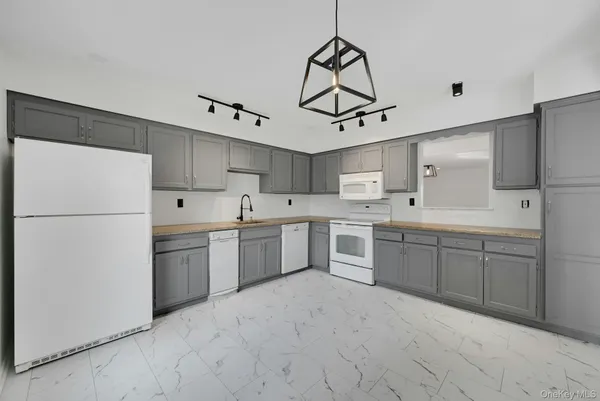 a kitchen with refrigerator cabinets and a sink
