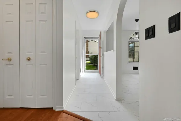 a view of a hallway with wooden floor and cabinet