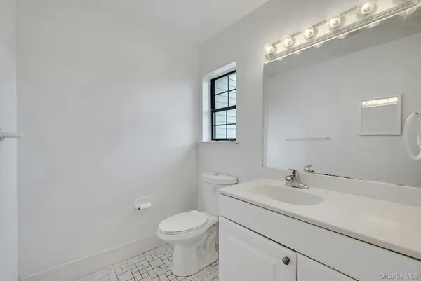 a bathroom with a sink a toilet and a mirror